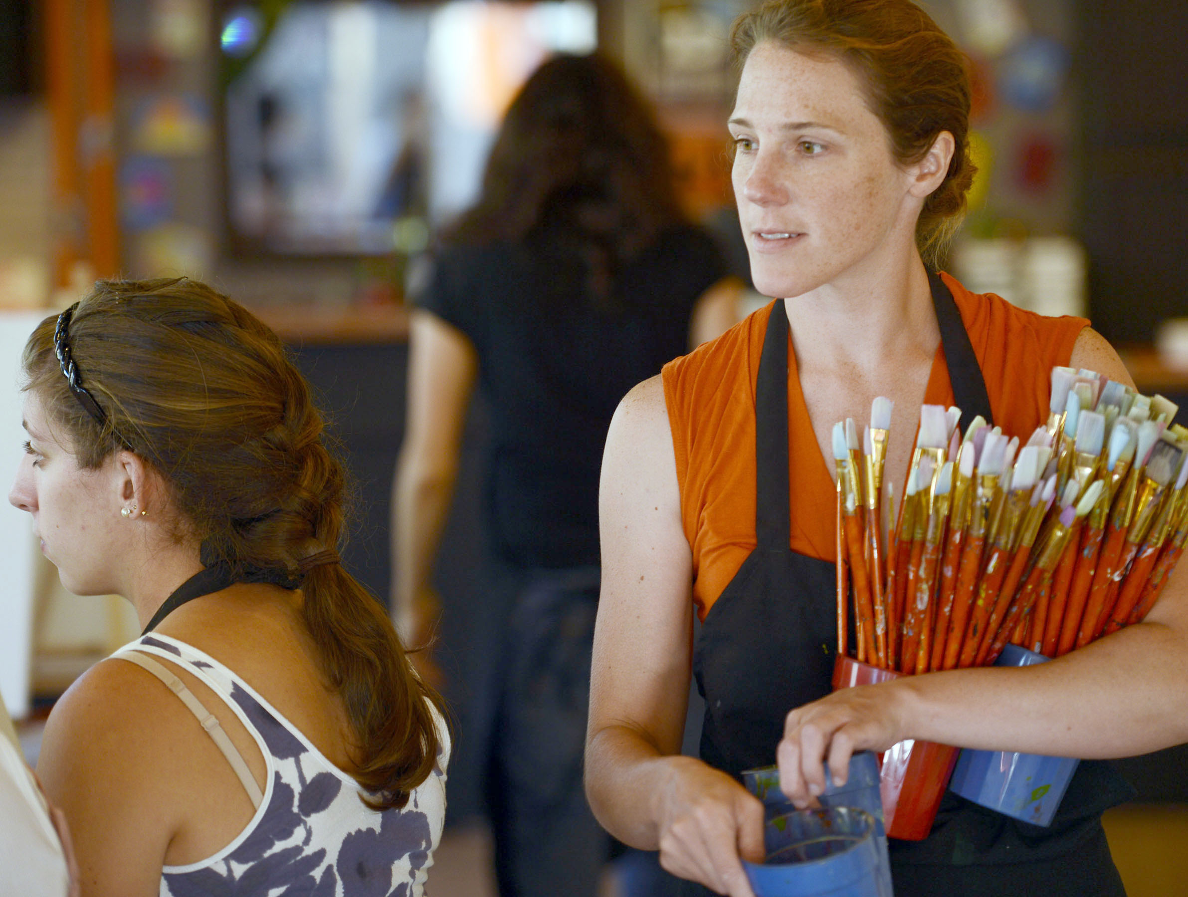 PETER R. BARBER/GAZETTE PHOTOGRAPHER Artist Kendra Farstad of Greenwich, hands out paint brushes at the Paint & Sip Studio on Henry Street in Saratoga Springs Wednesday, July 11, 2012.