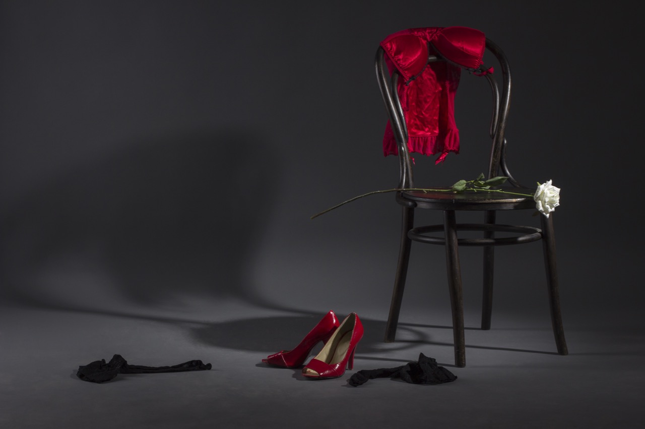 Sexy lingerie, shoes and a white rose on a retro chair.